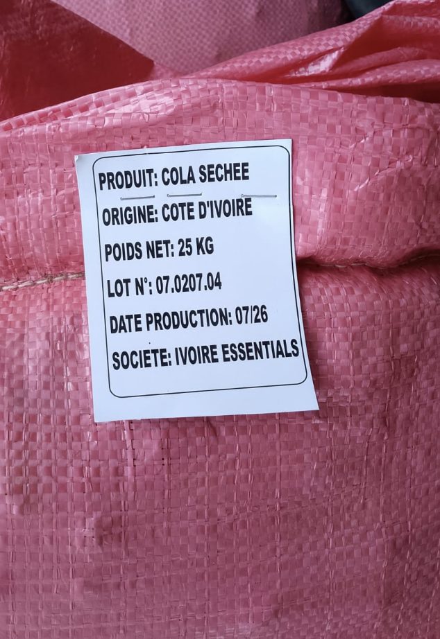 Ivoire Essentials label on a bag of dried cola nuts showing product, origin, net weight, lot number and production date